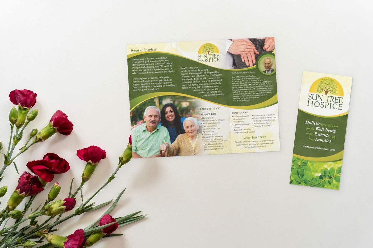 Sun Tree Hospice brochure open to panels about hospice care, the medical director and services, with a family photo, beside a narrow panel with the tree logo and tagline and red carnations.