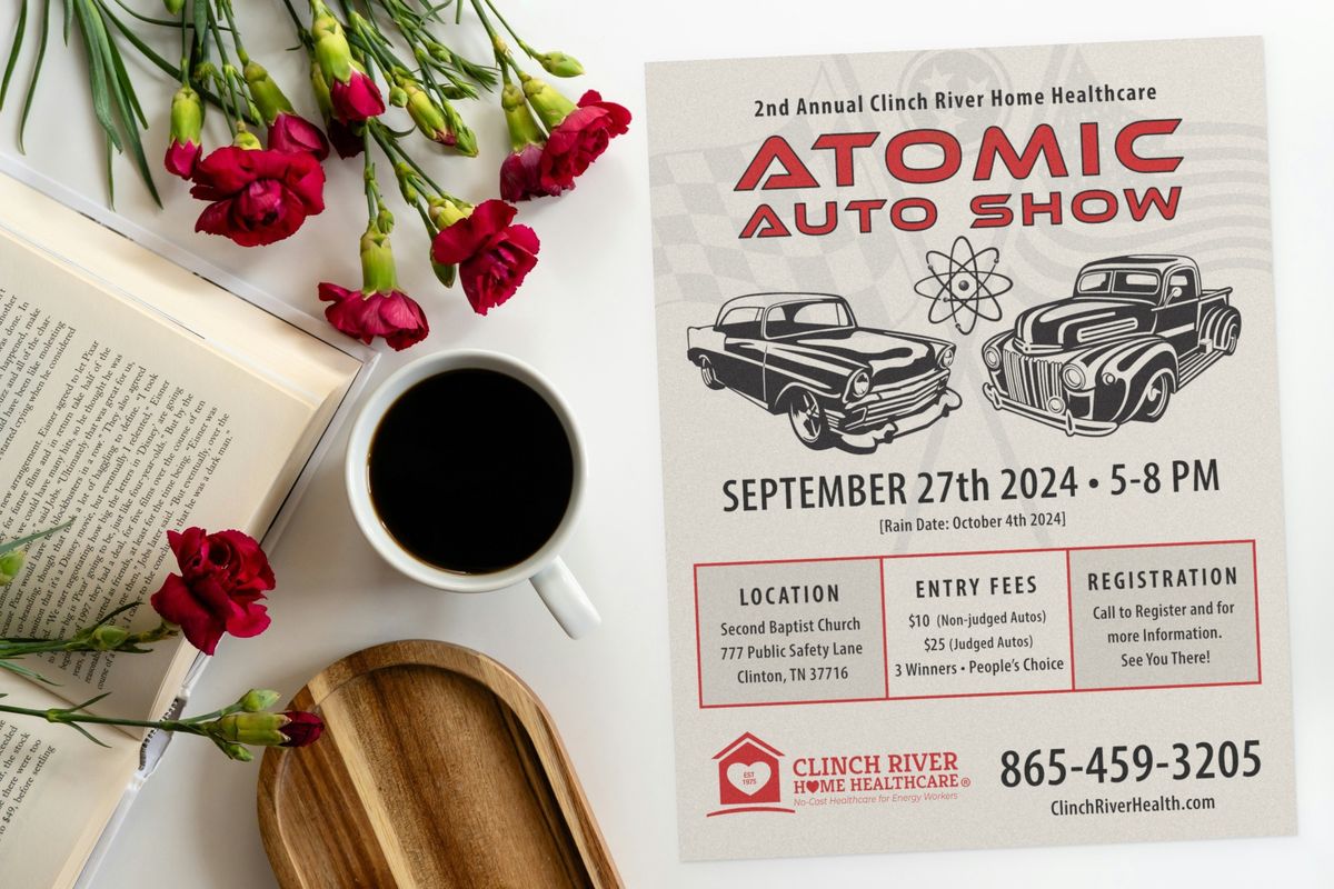 Atomic Auto Show flyer for Clinch River Home Healthcare, with red headline type, classic car and truck illustrations, the date, and a location, fees and registration panel, on a table with flowers and coffee.