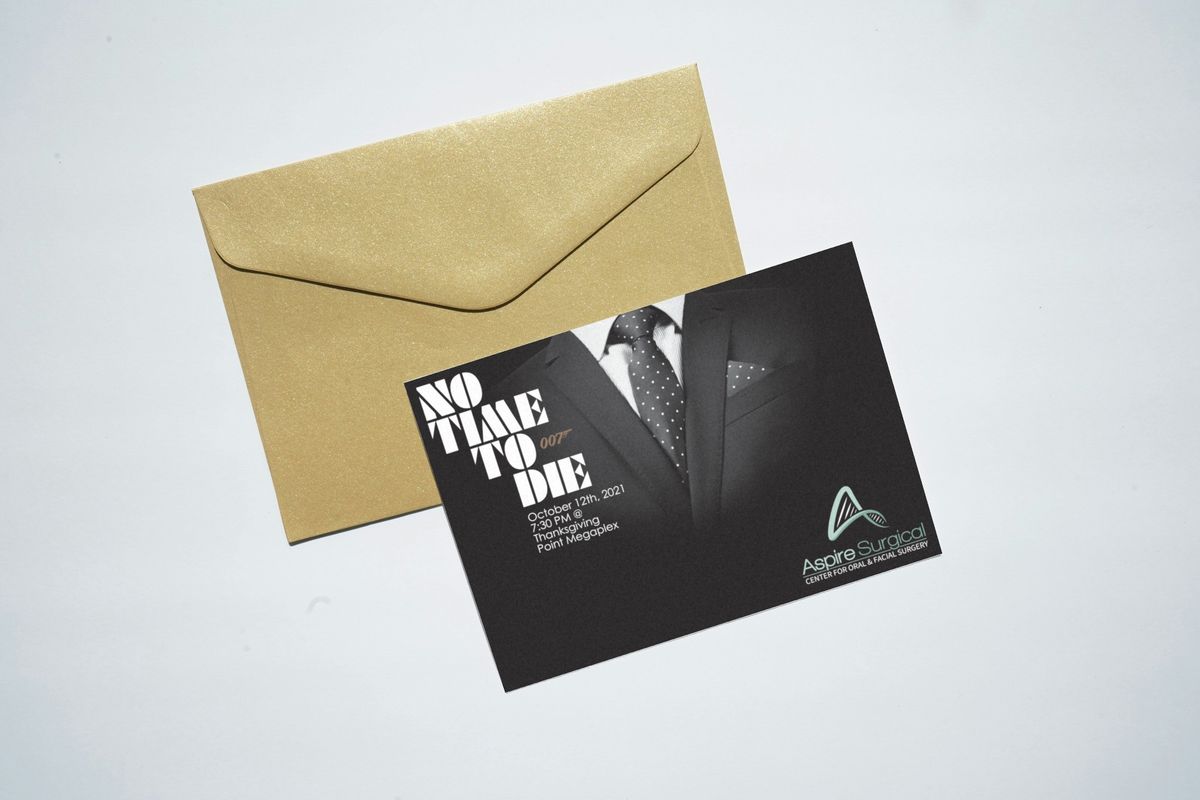 Aspire Surgical movie-night invitation postcard with a black-and-white photo of a suit and tie, "No Time To Die" lettering and the event details, lying on a gold envelope.